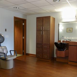 A salon interior with a hair drying station and mirror.