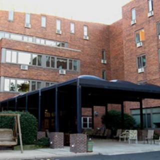 A brick building with a covered entrance and outdoor seating area.