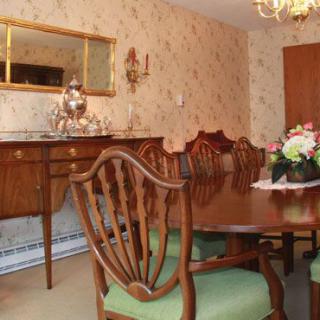 A classic dining room with elegant wooden furniture and a chandelier.