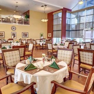 An elegant dining room with neatly arranged tables and chairs, featuring a warm and inviting atmosphere.