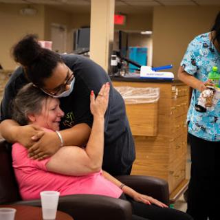 A heartfelt moment of care and connection between a caregiver and an elderly resident, highlighting the importance of emotional support in healthcare.