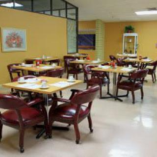 An empty dining area with neatly arranged tables and chairs.