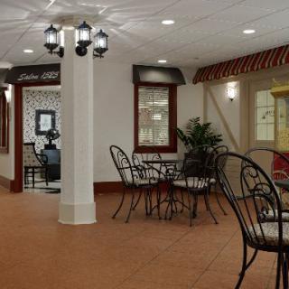 A cozy indoor cafe with elegant wrought iron tables and chairs, decorative lighting, and a warm ambiance.