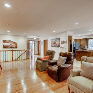 A cozy living room with recliner chairs and hardwood flooring, featuring an open layout leading to the kitchen.
