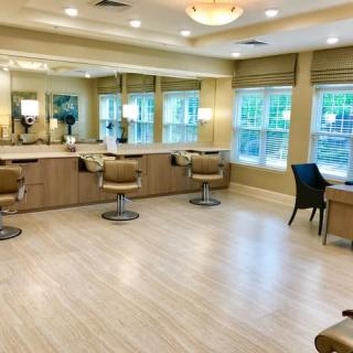 A modern and well-lit salon with multiple barber chairs and large mirrors.