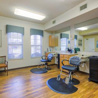 An inviting hair salon interior with comfortable chairs and large mirrors.