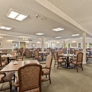 Spacious dining room with neatly arranged tables and chairs, well-lit and featuring elegant decor.