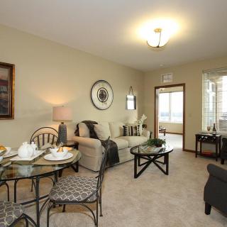 A cozy living room with an adjoining dining area, featuring comfortable seating and elegant decor.