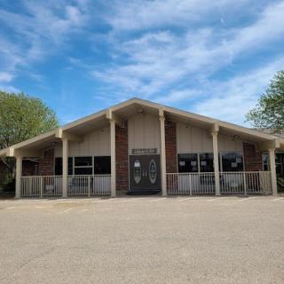 A modern commercial building with a unique architectural design, set against a clear blue sky.