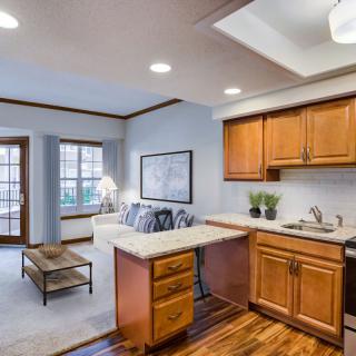 A well-lit open-concept kitchen and living room with wooden cabinets and modern decor.