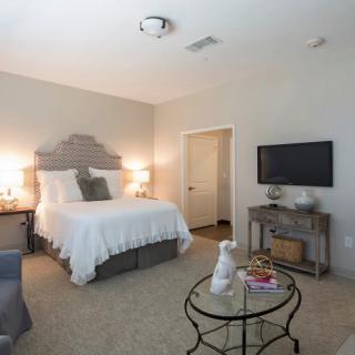 A cozy bedroom with a comfortable bed, nightstands with lamps, and a wall-mounted television.