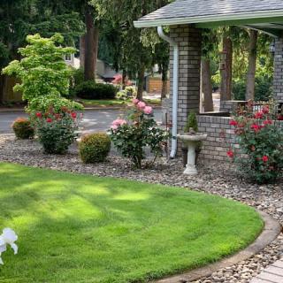 A beautifully landscaped garden featuring a gazebo, lush green grass, and vibrant flowers.