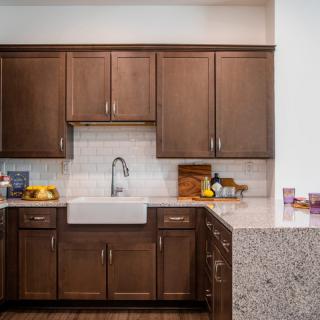 A modern kitchen with wooden cabinets and a farmhouse sink.