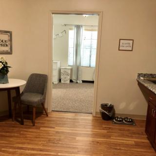 A cozy office space with a seating area, decorated with plants and artwork.