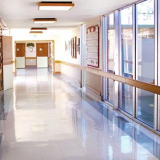 A bright and clean hospital corridor with large windows.