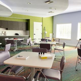 A modern conference room with tables and chairs arranged for meetings.