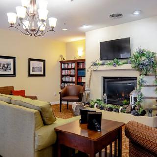 A cozy living room with a fireplace, comfortable seating, and elegant decor.