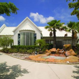 A beautiful house with palm trees and landscaped garden.