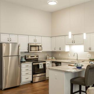 Modern kitchen with stainless steel appliances and white cabinetry.