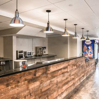 A modern kitchen with wood paneling and industrial-style lighting.
