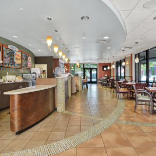 A spacious cafe interior with a counter and seating area.