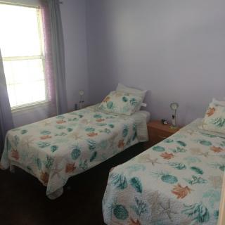 A cozy bedroom with two twin beds adorned with floral bedding.