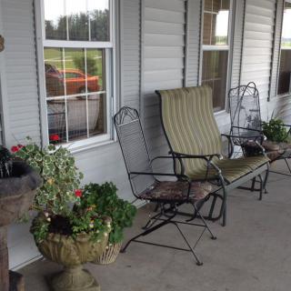 A cozy patio with seating and potted plants.