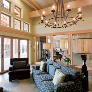A beautifully designed living room featuring modern decor, ample natural light, and an elegant chandelier.
