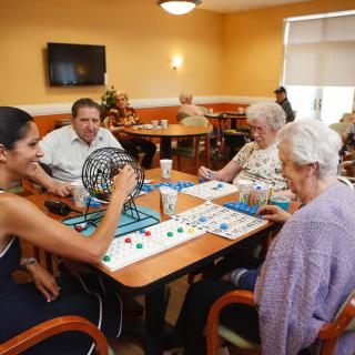 A group of people playing bingo together in a community center.