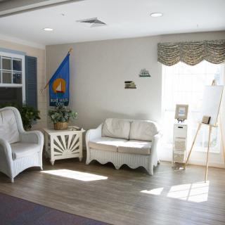A cozy living room with wicker furniture and warm sunlight streaming through the window.