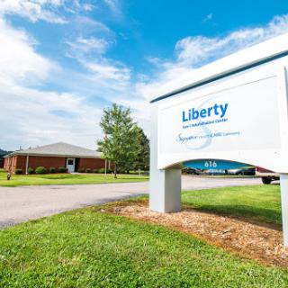 A view of the Liberty sign in front of a building on a clear day.