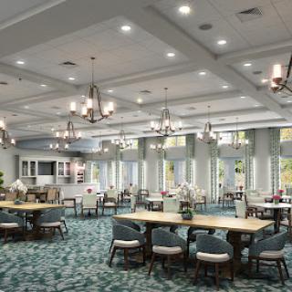 A spacious and elegantly designed dining area with ample natural light, featuring contemporary furniture and stylish lighting fixtures.