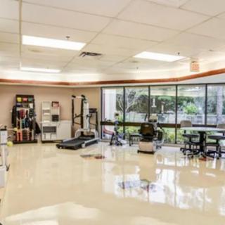 A spacious rehabilitation center equipped with gym and therapy equipment for physical therapy sessions.
