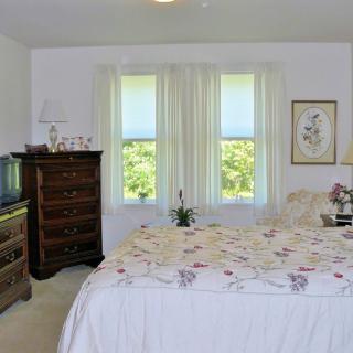 A cozy bedroom with a floral bedspread and classic wooden furniture.