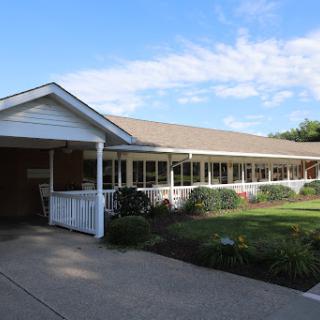 A charming residential building with well-kept landscaping under a blue sky.