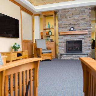 A cozy living room with a stone fireplace and wooden furniture.