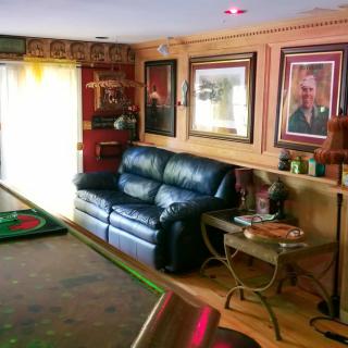 Cozy living room with leather sofa and framed photographs on the wall.