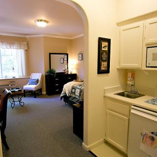 A cozy studio apartment with a bedroom and kitchenette.