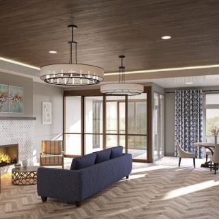 A modern living room featuring a blue sofa, fireplace, and large windows with stylish chandeliers and wooden ceiling.
