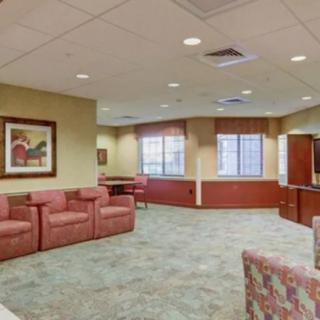 A spacious waiting room with comfortable seating and decorated walls.