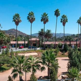 A scenic view of palm trees and mountains under a clear blue sky.