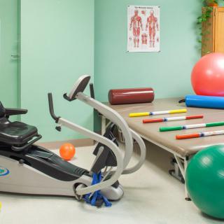 A therapy room with exercise equipment and colorful fitness balls.