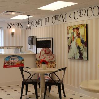 A cozy ice cream shop interior with vintage decor and seating.