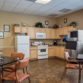 A cozy kitchen area with wooden cabinets and dining tables.