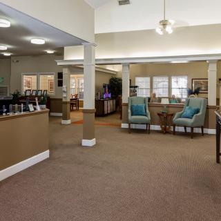 A spacious office interior with a waiting area featuring chairs and tables.