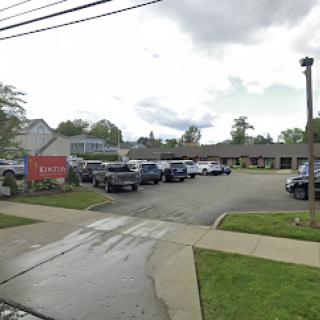 A view of a parking lot filled with various vehicles under a cloudy sky.