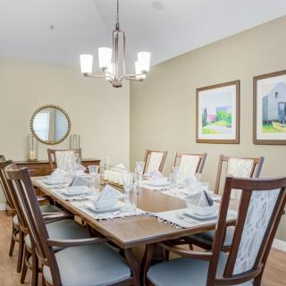 A modern dining room with a long table set for guests.