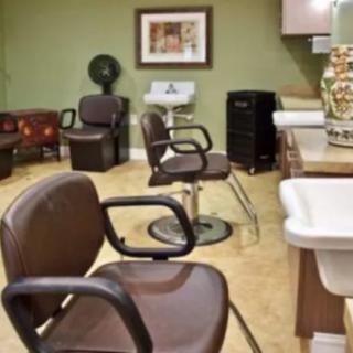 An interior view of a hair salon with empty chairs and beauty equipment.