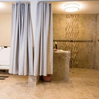 A modern bathroom featuring a shower area with elegant tiles and curtains.