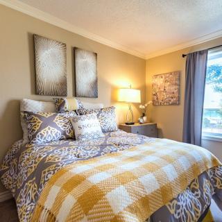 A cozy bedroom with warm lighting and patterned bedding.